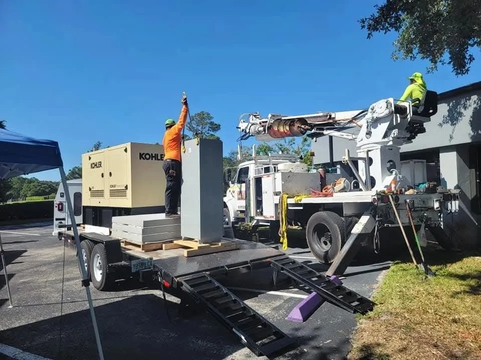 Crane truck delivering a Kohler generator to a job site