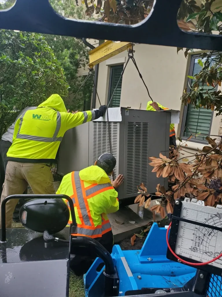 Installation crew lowering a generator into place