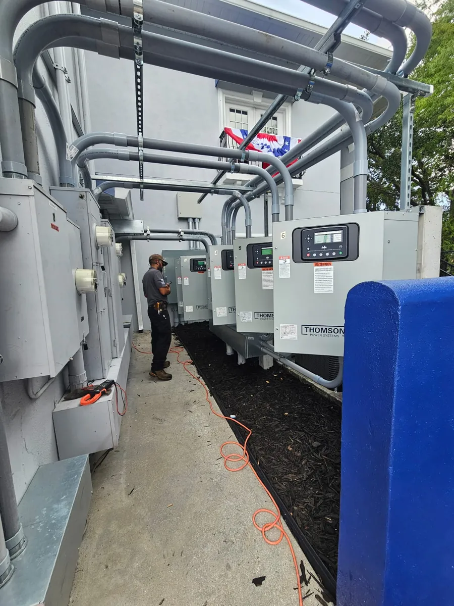 Technician inspecting a row of generator transfer switches