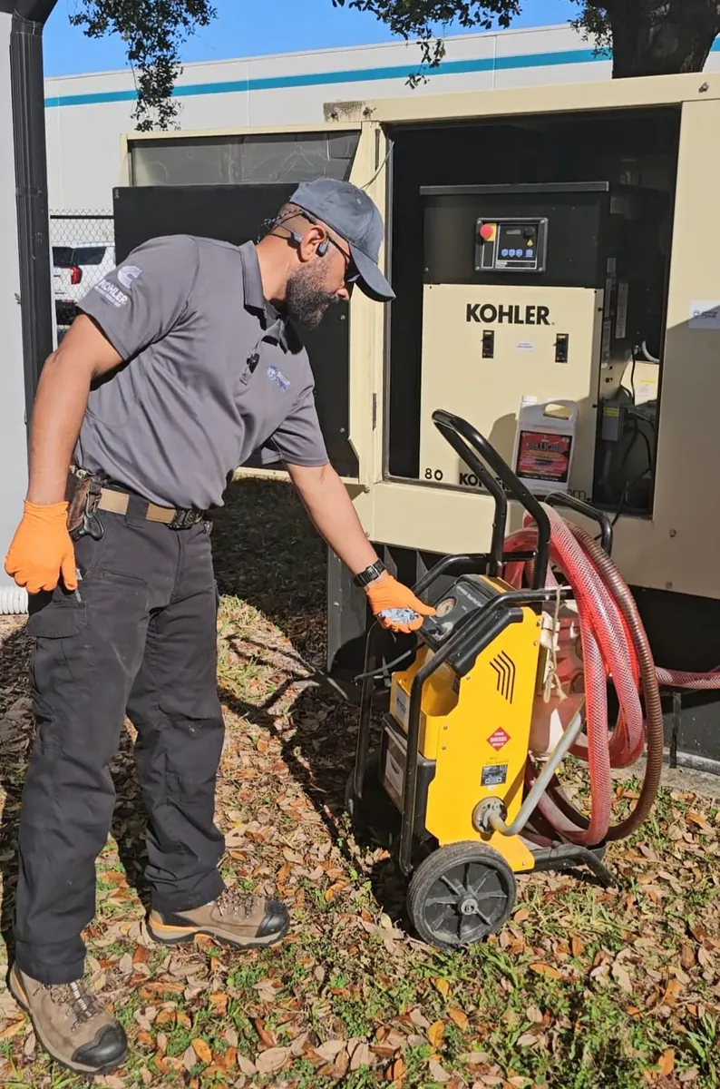 Technician performing planned maintenance on a Kohler generator